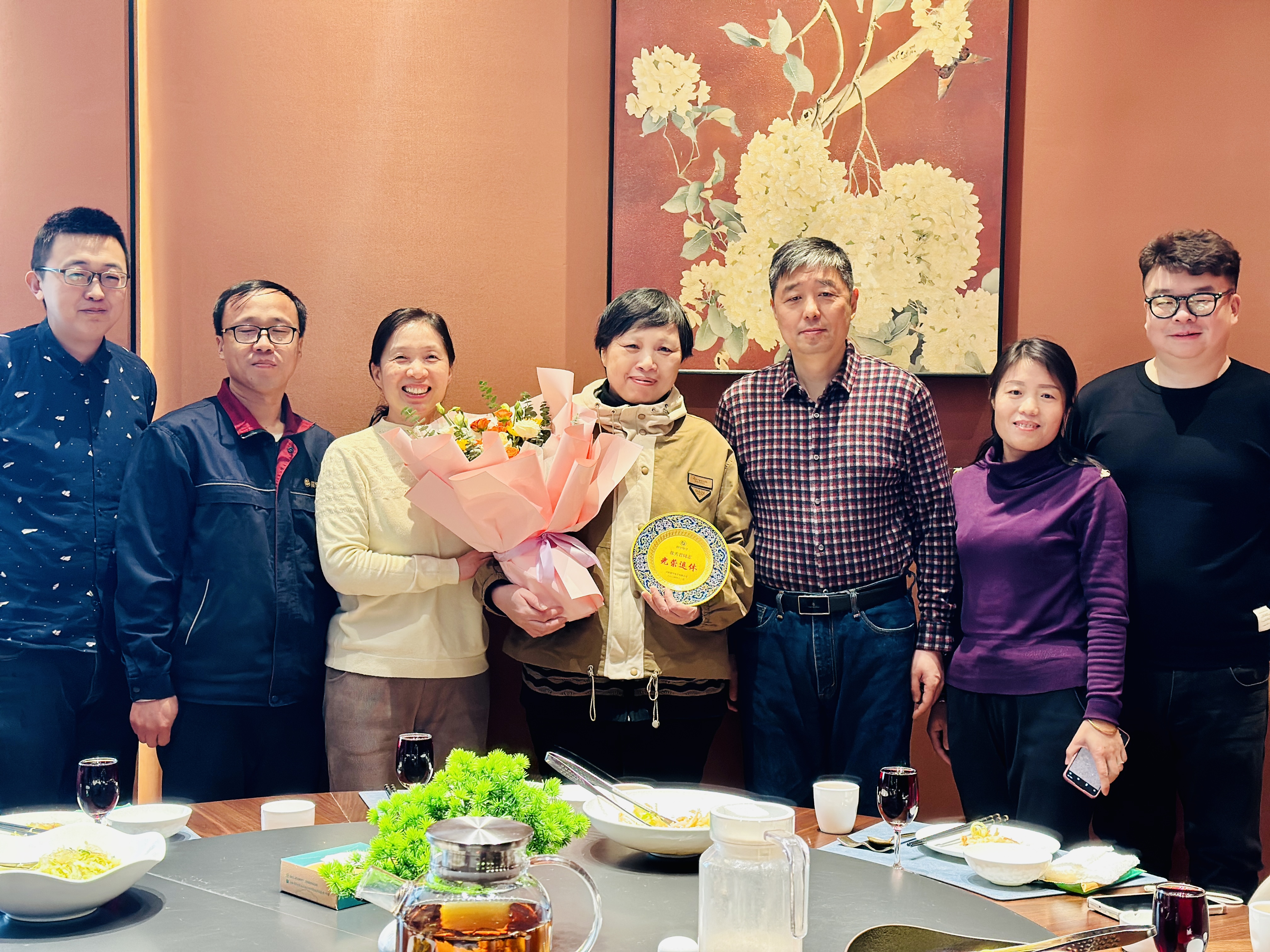 领导为退休员工颁发纪念品并合影留念