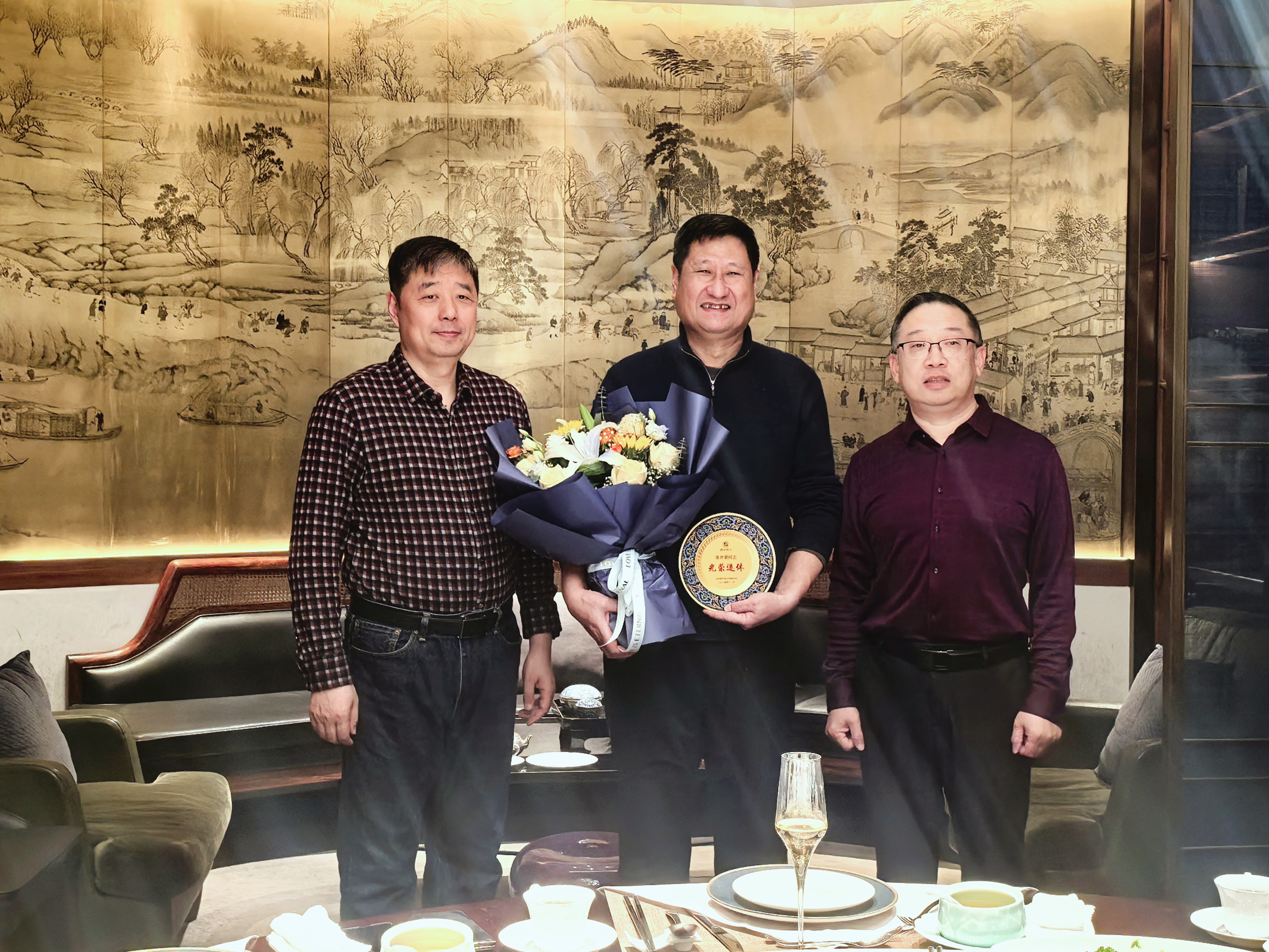 领导为退休员工颁发纪念品并合影留念